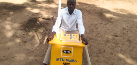 Alex at his Mobile money Kiosk Alex at his Mobile money Kiosk